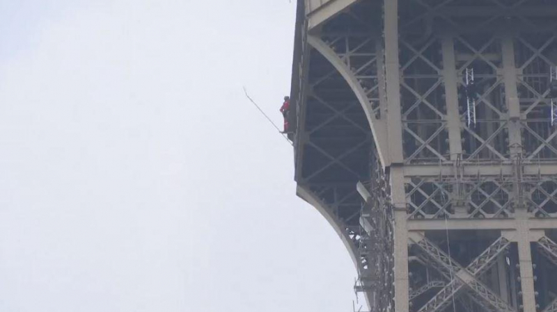 Un homme perché en haut de la Tour Eiffel tour eiffel